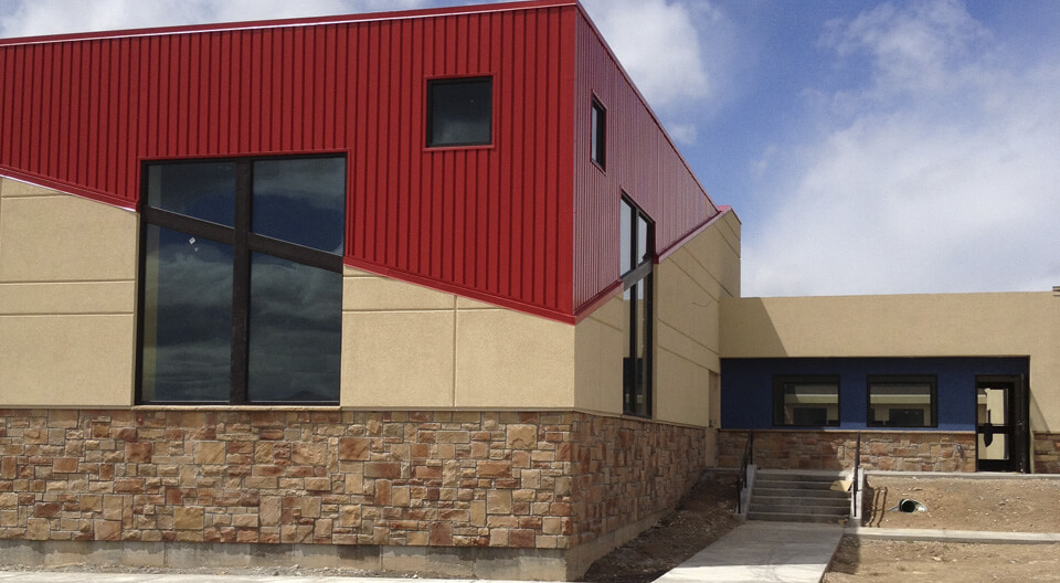 Washington Heights Addition in Ogden, UT - stucco siding with score lines - metal red siding-stone masonry work - Kids zone churches - tall windows - diagonal lines in buildings