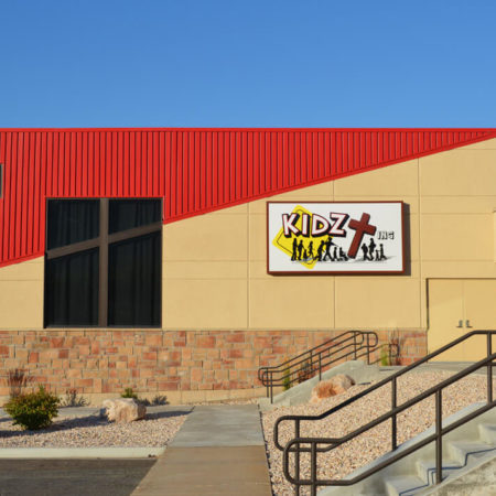 Washington Heights Addition in Ogden, UT - stucco siding with score lines - metal red siding-stone masonry work - Kids zone churches - tall windows - diagonal lines in buildings