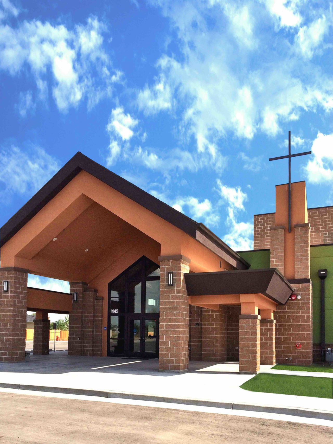 Idaho worship and community center. Church architecture church design. Mountain West Architects. Brick church exterior. Storefront church entrance. Gabled roof overhang church entrance.
