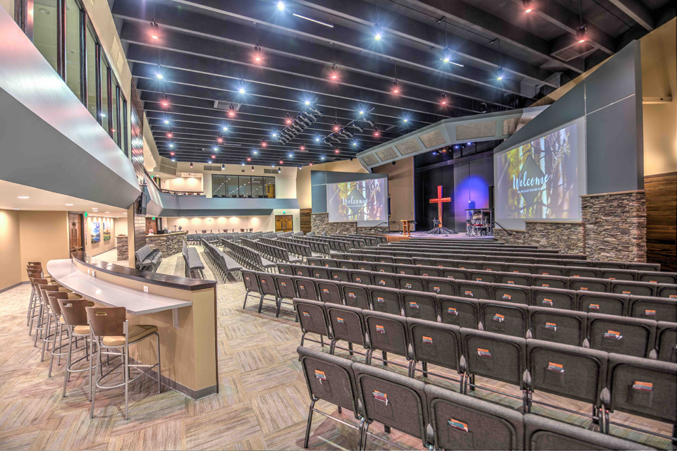 Picture of Pulpit Rock Auditorium Renovation, pendant lights, large worship seating, balcony viewing area in churches, glass partition in church assembly, exposed rafters in church interior, modern church sanctuary, wood trim in interior church building, modern church auditorium, multiple level church auditorium, church mezzanine