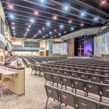 Picture of Pulpit Rock Auditorium Renovation, pendant lights, large worship seating, balcony viewing area in churches, glass partition in church assembly, exposed rafters in church interior, modern church sanctuary, wood trim in interior church building, church mezzanine