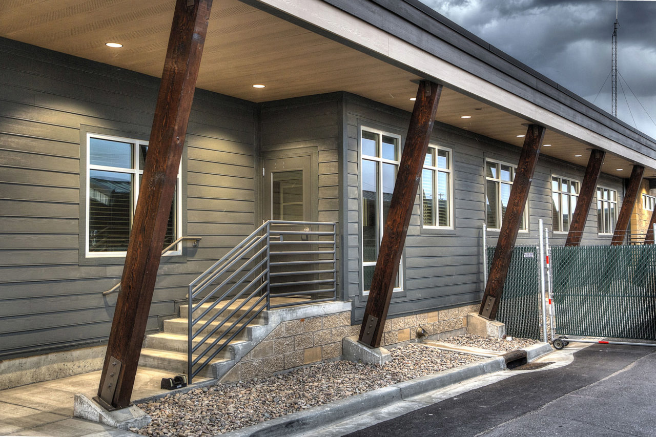 Wood siding, canned lights, exposed wood columns, exposed wood supports, neutral exterior color scheme